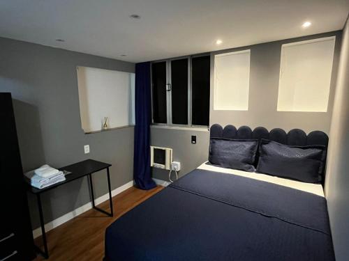a bedroom with a large bed and a desk at Verdito House in Rio de Janeiro