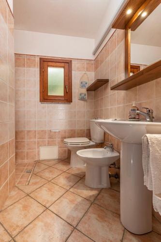 a bathroom with a sink and a toilet at Rosmarino veranda and pool with sunset view in Costa Paradiso