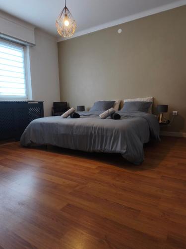 a bedroom with a large bed in a room with wooden floors at S'heimet Hüüs in Colmar