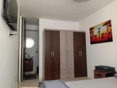1 dormitorio con armarios de madera y lavamanos en Apartaestudio Armenia quindio, en Armenia