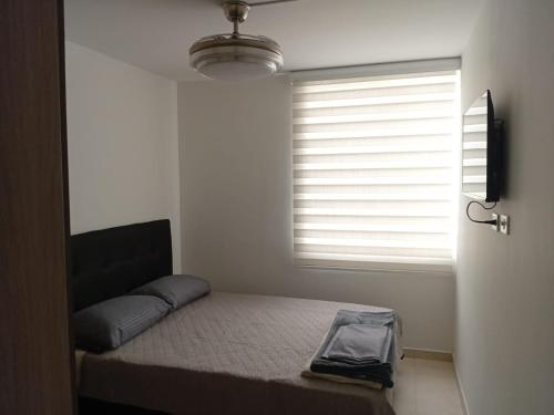Un dormitorio pequeño con una cama y una ventana. en Apartaestudio Armenia quindio, en Armenia