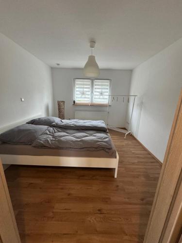 a white bedroom with a bed and a window at Ferienhaus Auf der Drossel in Gevelsberg