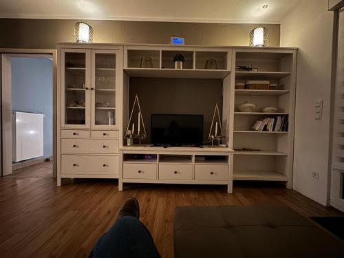 ein Wohnzimmer mit einem großen weißen Entertainment-Center in der Unterkunft Ferienhaus Auf der Drossel in Gevelsberg