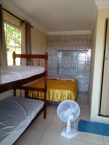 a room with two bunk beds and a fan at Recanto Jane e Daniel in Angra dos Reis