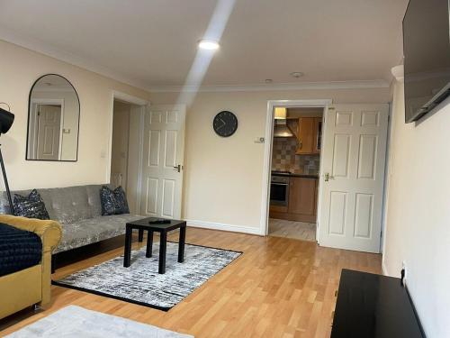 a living room with a couch and a table at Cozy apartment, sleeps 4 with TV in Gillingham