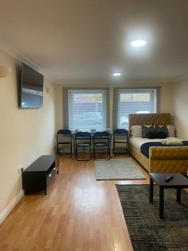 a living room with a bed and a table and chairs at Cozy apartment, sleeps 4 with TV in Gillingham