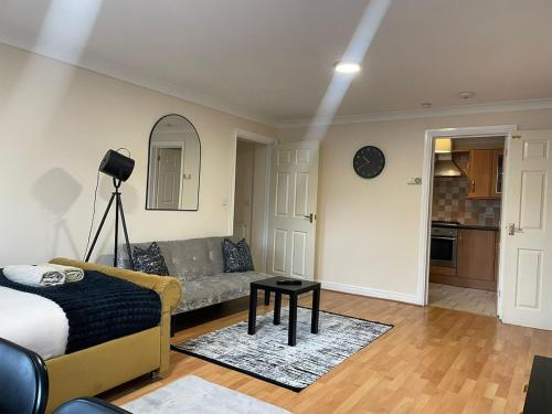 a living room with a couch and a table at Cozy apartment, sleeps 4 with TV in Gillingham