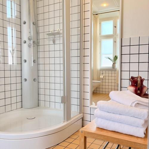 a bathroom with a shower and a tub and towels at Brodremenighedens Hotel, BW Signature Collection in Christiansfeld