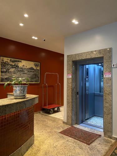 a lobby with a blue door and a red wall at Tarik Fontes Plaza Hotel in Itabuna