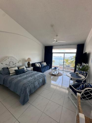 a bedroom with a bed and a view of the ocean at Santorini, loft frente al mar in Manzanillo