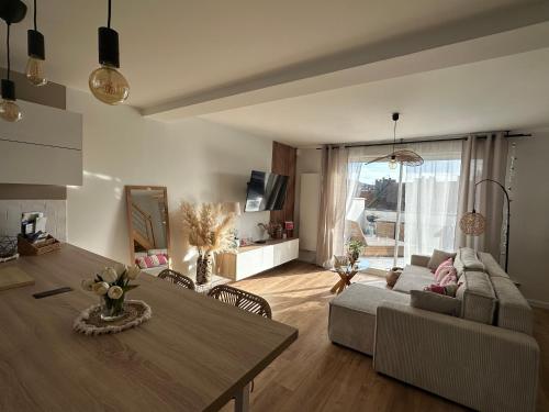 a living room with a couch and a table at La parenthèse Parking Privatif in Boulogne-sur-Mer