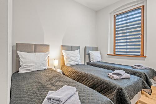 two beds sitting next to each other in a room at Central Platinum Apartments 4 in Rybnik