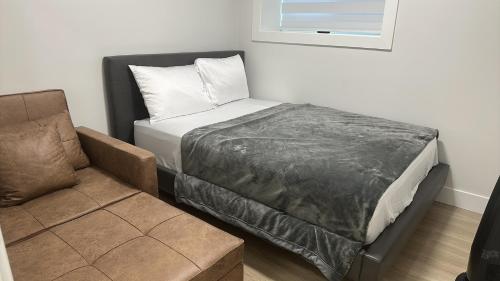 een bed en een stoel in een kamer bij Metrotown area in Vancouver