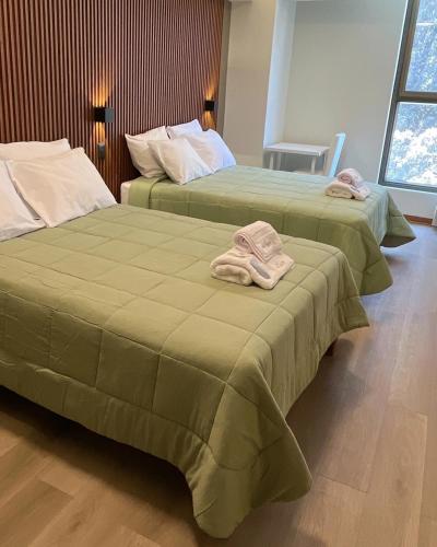 two beds with towels on them in a room at LAS CONDES Hotel in Tacna