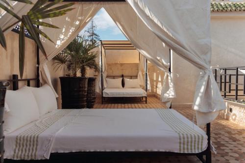 a bedroom with a bed and a chair on a balcony at Riad Valentine in Marrakech