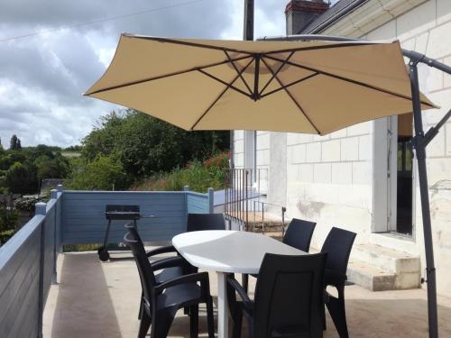 洛什Ma Maison Vigneronne的庭院里配有桌椅和遮阳伞