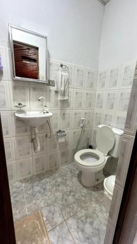 a bathroom with a toilet and a sink at Chácara Canto Dos Pinheiros in Vargem Grande Paulista