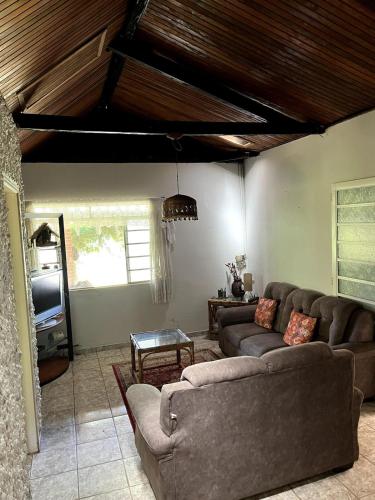 a living room with two couches and a tv at Chácara Canto Dos Pinheiros in Vargem Grande Paulista