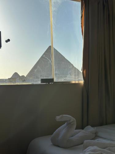 Una habitación con una ventana con vista a las pirámides. en Anyma Pyramids View Inn, en El Cairo