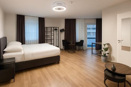 ein Schlafzimmer mit einem Bett, einem Schreibtisch und einem Tisch in der Unterkunft la Plaza24 in Düsseldorf