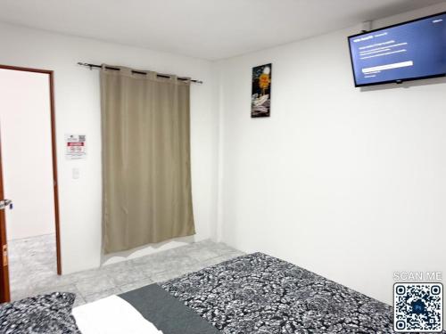 a bedroom with a bed and a flat screen tv at Hotel la Cruz in Querétaro