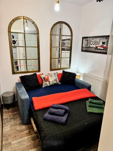 a living room with a couch and two mirrors at LOFT Studio Wielicka in Krakow
