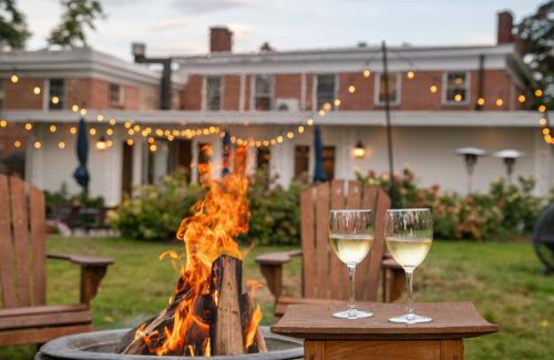 two glasses of white wine on a table next to a fire at Cromwell Manor Inn in Cornwall-on-Hudson