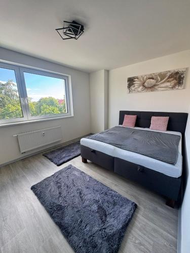 a bedroom with a large bed and two rugs at Apartmán Sova in Ostrov
