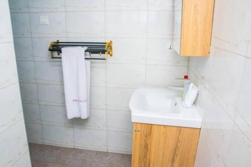 un bagno con lavandino e asciugamani appesi a una parete di feel at home luxury suit a Sekondi-Takoradi