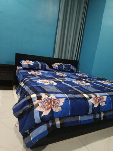 Una cama azul con una colcha azul y blanca encima en Private home with short lets, en Uyo