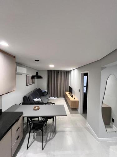 a kitchen and living room with a table and a couch at Priority Praia grande in Praia Grande