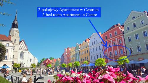 a view of a city street with pink flowers at Apartament Przy Starówce - Bella in Bolesławiec