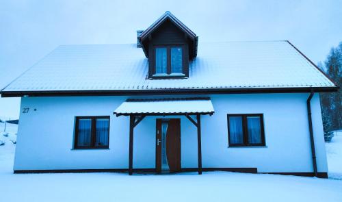 NielbarkBiały Domek Nielbark - Agroturystyka的白色房子,有雪盖屋顶