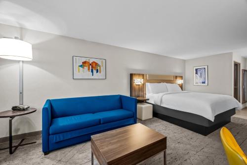 una camera d'albergo con un letto e un divano blu di Holiday Inn Express Monticello by IHG a Monticello