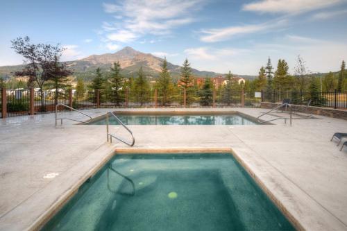 大天山村Big Sky Getaway Lone Peak Views Shared Hot Tub的以山为背景的游泳池