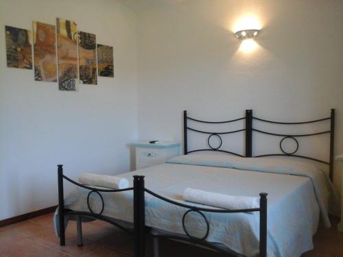una camera con un letto e due quadri appesi al muro di Santu Paulu Country House a Posada