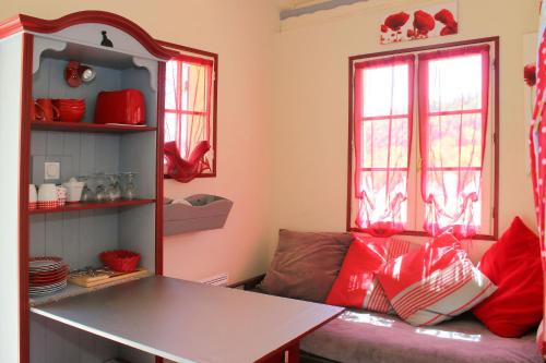a living room with a couch and red pillows at La Roche Bleue in Saint-Bois