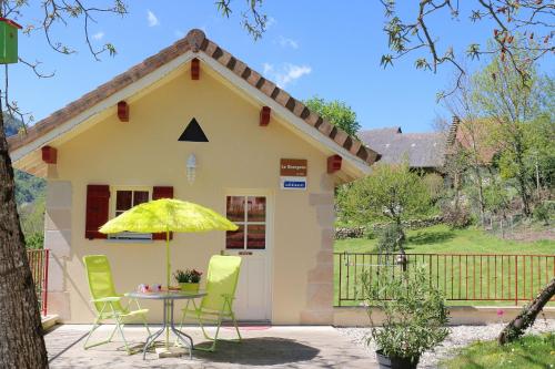 a small yellow house with a table and chairs at La Roche Bleue in Saint-Bois