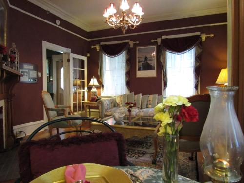 a living room with a table with a vase of flowers at Peace & Plenty Inn Bed and Breakfast Downtown St Augustine-Adults Only in Saint Augustine