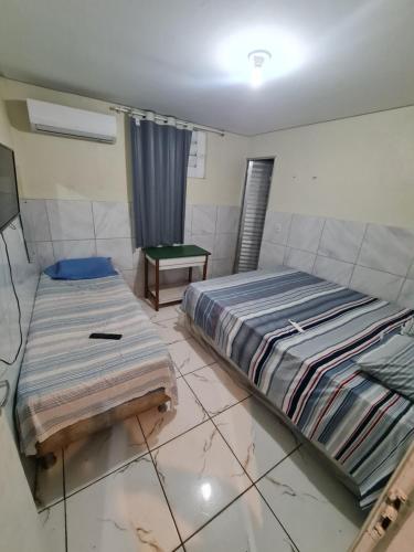 a bedroom with a bed and a table in it at Elite Hotel Prime in Teresina