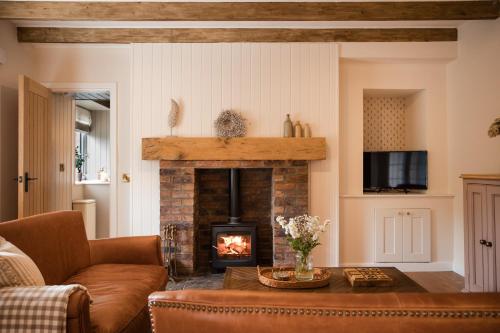 a living room with a fireplace and a couch at Briar Cottage Paxton, Berwick Upon Tweed in Berwick-Upon-Tweed