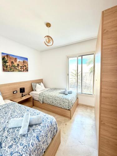 a bedroom with two beds and a window at Charmante maison de vacances proche de la plage à quelques minutes de Rabat in Temara