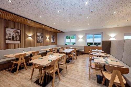 a dining room with wooden tables and chairs at Hotel & Gasthof Taferne in Schladming