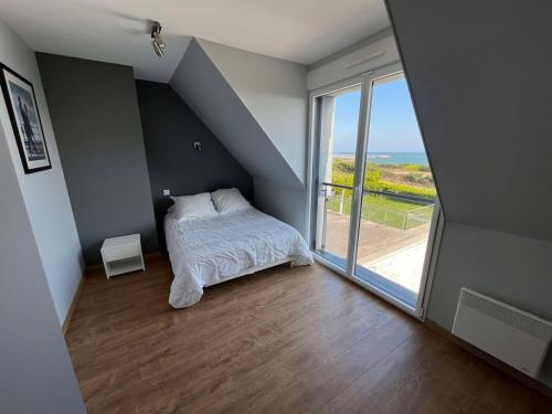 una camera da letto con un letto e una grande finestra di Villa Residence Kersaliou a Roscoff