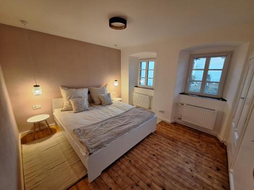 a bedroom with a white bed and two windows at S & C Ferienhaus in Oberbettingen