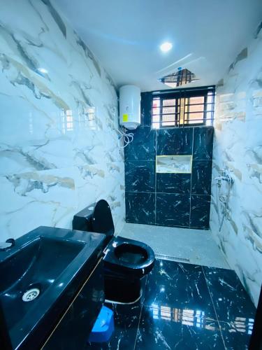 a bathroom with a black toilet and a sink at Résidence de la Paix in Yaoundé