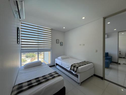 ein Schlafzimmer mit zwei Betten und einem Fenster darin in der Unterkunft Edificio Ocean Club in Santa Marta