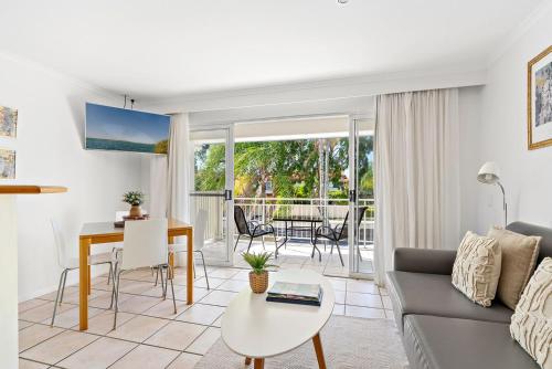 a living room with a couch and a table at At The Sound Noosa in Noosaville