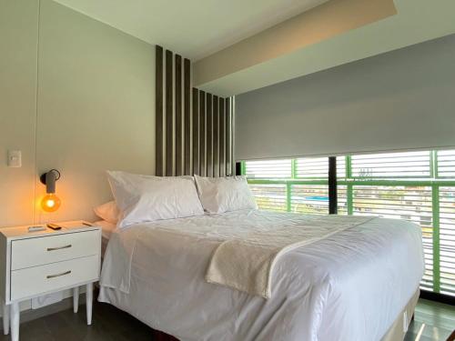a bedroom with a white bed and a window at Modern 2BR with Balcony in San Isidro in Lima