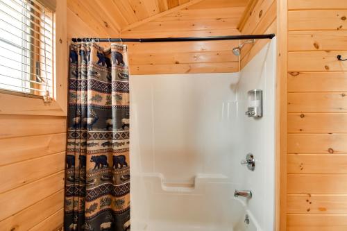 a bathroom with a shower with a shower curtain at Shared Dock Access at Lakeside Sodus Bay Cabin! in North Rose